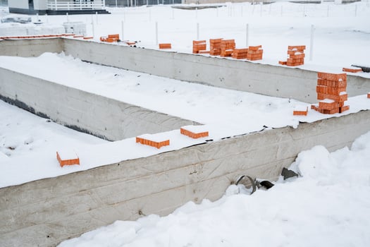 At the construction site, theres an impressive amount of snow covering the ground, creating a winter wonderland that stands in contrast to the construction equipment around photo