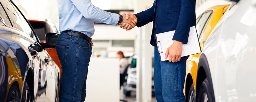 Sales manager shaking customer hand, celebrating successful deal, side view, cropped. Unrecognizable rich man buying brand new sports automobile at luxury showroom, panorama photo