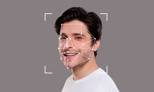A young man smiles while facial recognition technology analyzes his features. The digital overlay highlights key facial points for identification. photo