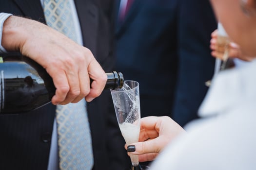 a man is pouring champagne into a glass photo