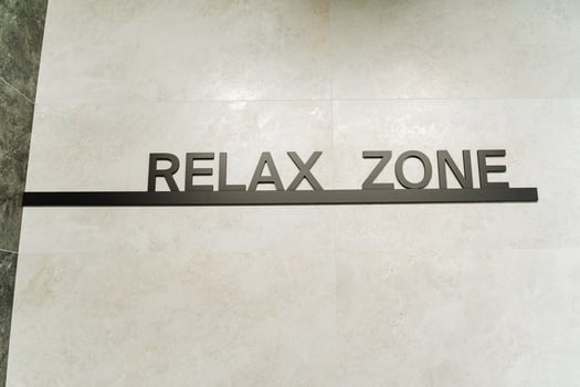 A Relax Zone sign on the floor is a key part of the buildings branding, adding to the ambiance with a unique design and message, fostering a welcoming atmosphere for visitors and patrons photo