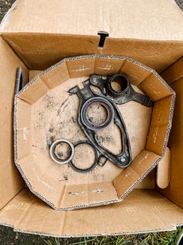 Fashion accessory of assorted metal pieces in a wooden packaging with a beige pattern on hardwood photo