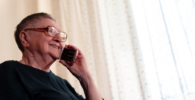 Senior citizen uses a handheld gadget to connect with family, demonstrating how technology can enhance intergenerational relationships photo