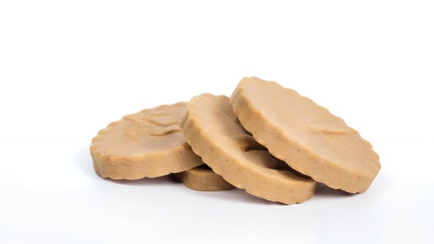 Three round beige pet treats on white background. photo
