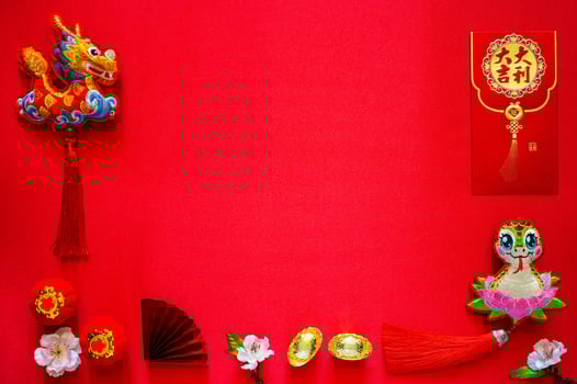 Chinese new year background with envelope packet or ang bao word mean auspicious, ingots word mean wealth, hanging pendant dragon and snake on red cloth background. photo