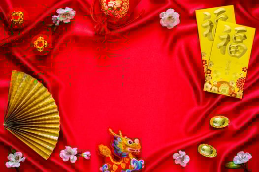 Chinese new year background with envelope packets or ang bao word mean blessing, red bag and ingots words mean wealth, hanging pendant dragon on red cloth background. photo