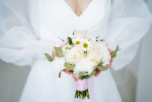 A bride holding a bouquet of white flowers photo