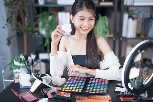 beauty blogger review beauty and cosmetics, makeup and beauty concept - asian woman with makeup and cosmetics photo