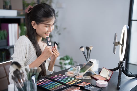 woman is sitting at a table with makeup products photo