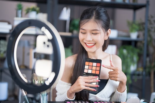 a woman holding makeup and look up smartphone photo