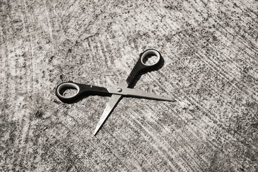 Mini scissors on cement floor. Monochrome of paper cutting tools. Unique office equipment. Negative space. Wallpaper. Backgrounds. Isolated Objects Photography concepts photo