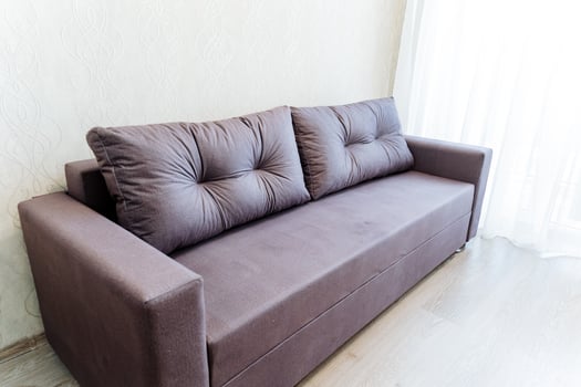 Furniture A brown couch in a living room by window, on hardwood flooring photo