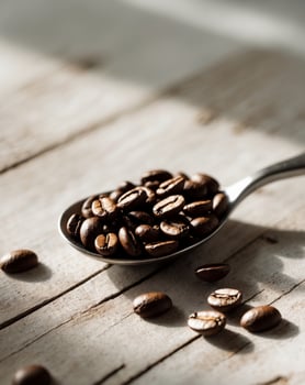 A spoonful of coffee beans on a wooden tableA spoonful of coffee beans on a wooden table. photo