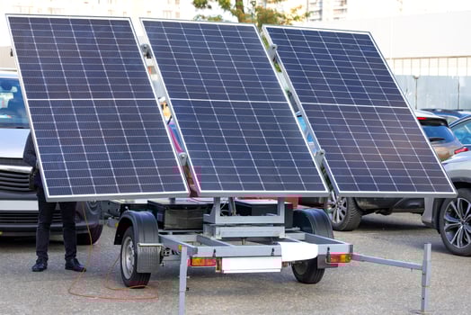 Large solar panels on a trailer hitch in a car parking lot. photo