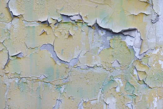 Old paint peeling off in large chunks on a concrete wall. photo