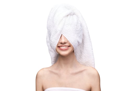 Young caucasian female with towel wrapped around head smiling, white background. photo