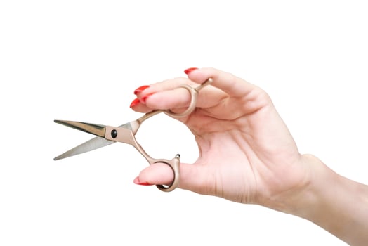 Caucasian female hand holding small scissors with red manicured nails on white background. photo