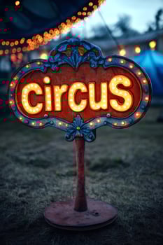 Illuminated circus sign stands in field at dusk, announcing entertainment photo