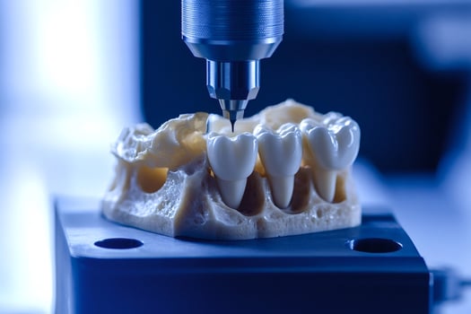 Dental milling machine carving a ceramic tooth crown on a jaw model photo