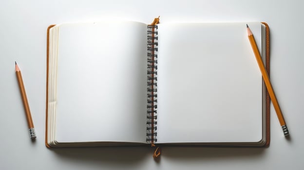 Open notebook with pencils on white background photo