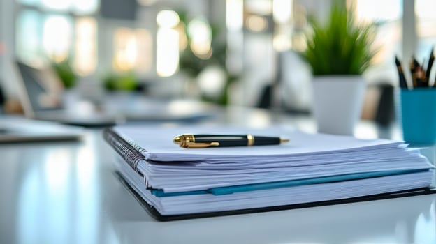 A stack of papers and a pen on a desk photo