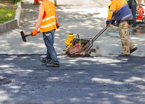 Construction workers skillfully paving a new road on a sunny day with innovative machinery photo