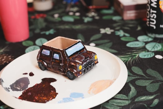 A vibrant and colorful miniature car craft beautifully displayed on an artistic plate photo