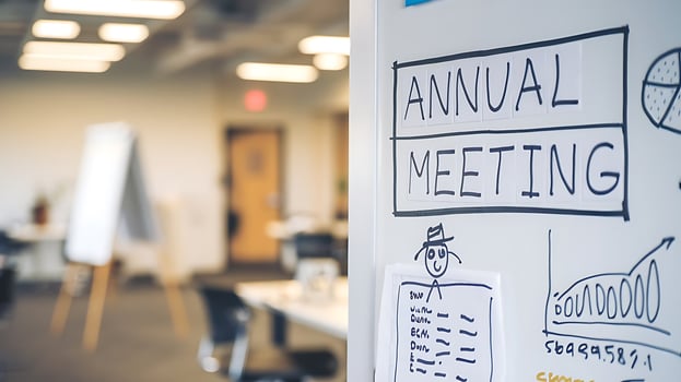 A whiteboard with the words ANNUAL MEETING, business graphs and a cartoon drawing for a business discussion photo
