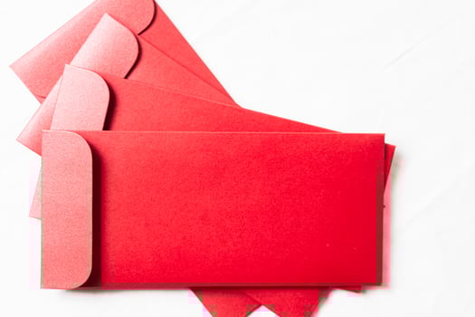 Stack of Vibrant Red Envelopes on White Surface photo