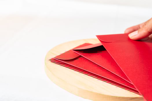 Festive Red Envelopes on Wooden Platter photo