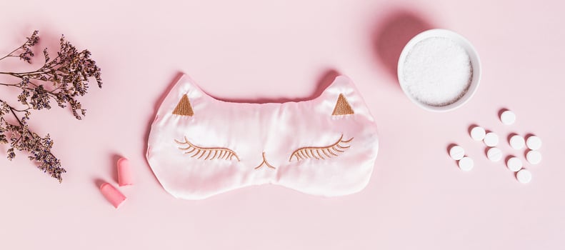 Concept insomnia sleep mask, earplugs, sleeping pills and magnesium powder on pink background photo