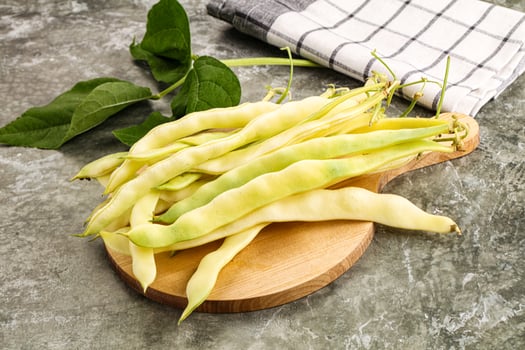 A bunch of green beans on a wooden cutting board photo