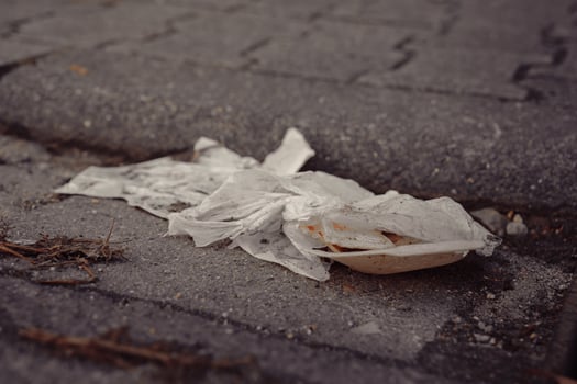 Trash discarded on city street showcases urban litter issues and environmental concerns in a metropolitan area photo