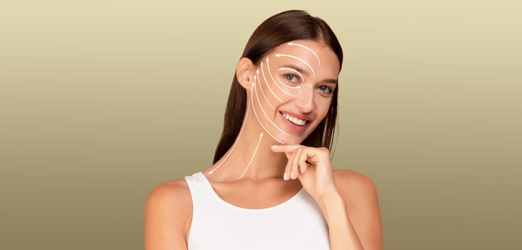 A woman engages in her skin care routine, smiling while caring for her skin. The background is soft and neutral, emphasizing her commitment to self-pampering and beauty. photo