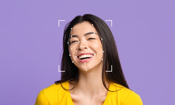 A young woman smiles brightly against a purple backdrop, with facial recognition markers overlaying her face. This technology highlights the emerging field of identity verification and analysis. photo