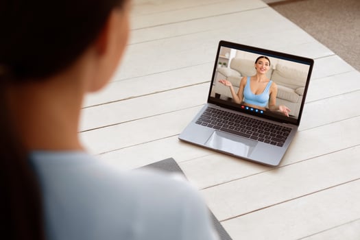 Unrecognizable Woman At Laptop Watching Fitness Blog Online Sitting And Training Staying At Home. Selective Focus, Back View photo