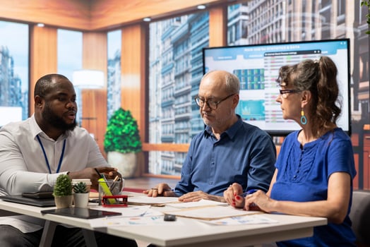 Mature couple in a detailed discussion with financial expert about retirement plan and savings growth. Receiving tailored financial advice on pension planning, investment strategy. photo