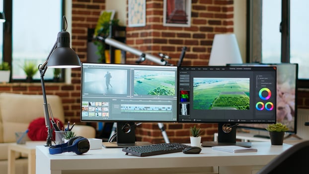 Modern digital workspace in the living room focused on tech and productivity, dual monitors displaying post production tools for creation. Clean desk setup supports efficient production. photo