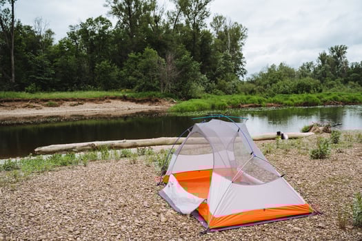 Experience a peaceful camping trip by the river with tent stay and beautiful nature views. Ideal for relaxation and outdoor adventures in a tranquil forest setting photo