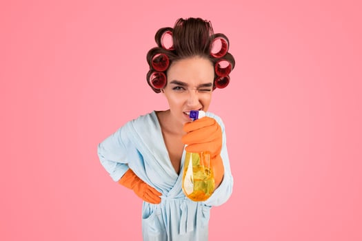 Keep House Clean. Housewife Holding Detergent Bottle Looking At Camera Cleaning Home Posing On Yellow Studio Background. Vertical photo