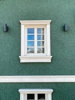 Green building with white window and wooden fixture photo