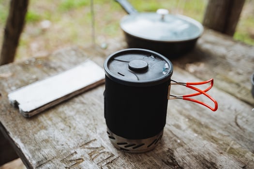 A cup with red handles is sitting on a wooden table photo