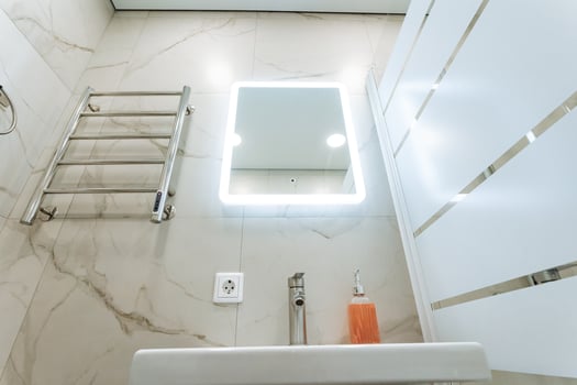Explore a modern bathroom interior that features a stylish mirror along with sleek design elements, providing both comfort and elegance photo