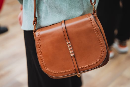 A woman carries an electric blue shoulder bag with a strap on her shoulder photo