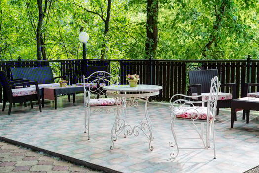 The serene outdoor patio includes a table, chairs, and trees, perfect for relaxation and outdoor activities. It offers a peaceful atmosphere for leisure and enjoyment in nature photo