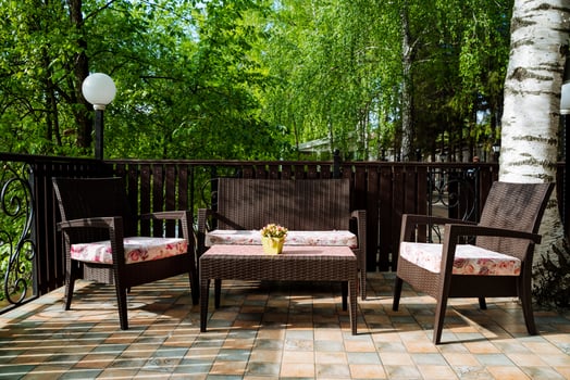 A beautifully furnished patio features a couch, chairs, table, and potted plant, creating a cozy outdoor space for relaxation and enjoyment in a natural landscape setting photo