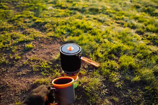 Tableware cup and pot resting on grassy groundcover photo