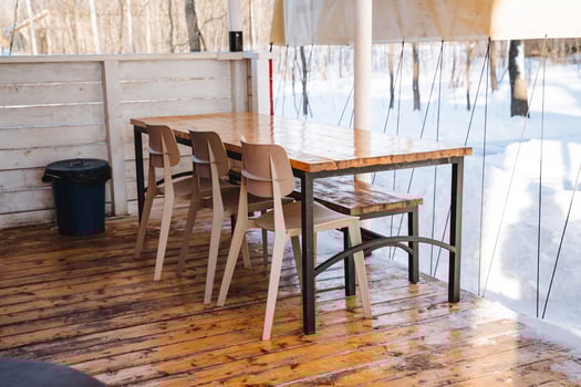 A beautifully crafted wooden table accompanied by a set of charming chairs is resting majestically on a sturdy wooden floor, creating a warm and inviting atmosphere in the room photo