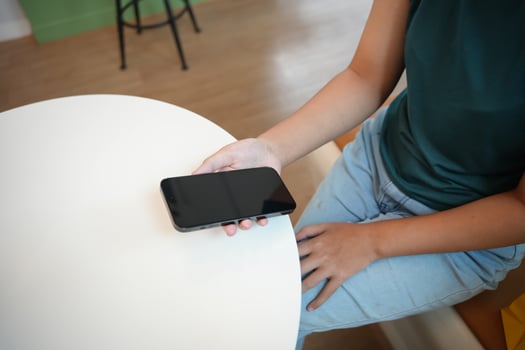 woman sitting at a table with a cell phone photo