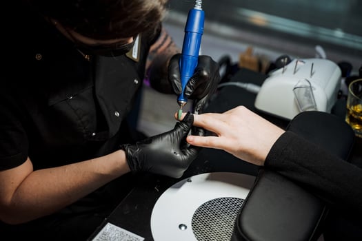 A man is using an automotive tire machine on a womans nails photo
